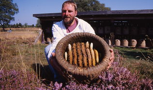 Imkermeister Wolfgang Stöckmann mit einem Bienenkorb "Lüneburger Stülper"
